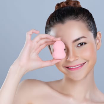 Glamorous beautiful female model applying cushion powder for facial makeup concept. Portrait of flawless perfect cosmetic skin woman put powder puff on her face in isolated background.