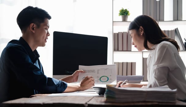 Businesswoman holding pens and holding graph paper are meeting to plan sales to meet targets set in next year