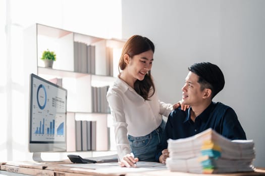 Two business people talk project strategy at office meeting room. Businessman discuss project planning with colleague at modern workplace while having conversation and advice on financial data report...