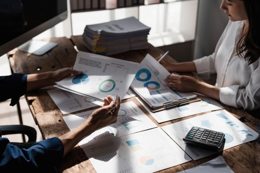 Business People Meeting using laptop computer,calculator,notebook,stock market chart paper for analysis Plans to improve quality next month. Conference Discussion Corporate Concept....