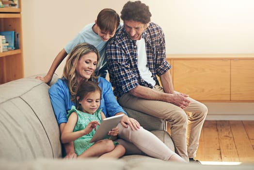 Getting more out of family time with modern technology. a happy family using a digital tablet together at home