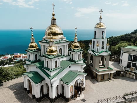 Christian church on a background of mountains. Temple of the Holy Archangel Michael in Oreanda. The southern coast of Crimea. Located on a rocky cliff and is surrounded by beautiful vegetation