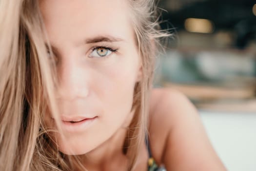 Happy woman portrait in cafe. Boho chic fashion style. Outdoor photo of young happy woman with long hair, sunny weather outdoors sitting in modern cafe