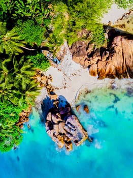 Drone view from above at a tropical beach in Seychelles. Anse Volbert beach Praslin with granite boulders rocks