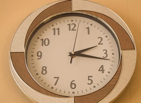 Round wall clock shows the time 2 hours and 15 minutes on light dial.