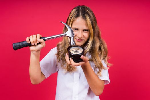 Kid girl holding hammer and alarm clock smiling with happy and cool smile on face. showing teeth.