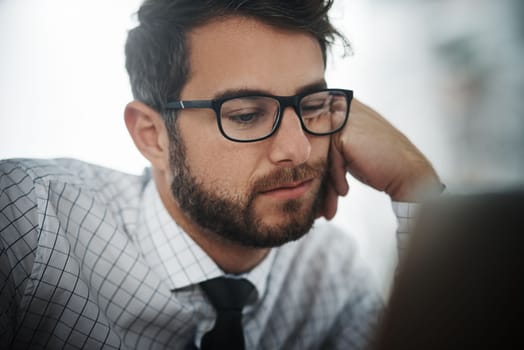 I cant look interested even if I tried. a young businessman looking bored while working in an office