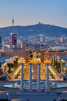 Barcelona at dusk with the Plaza de Espana and Mount Tibidabo in the back