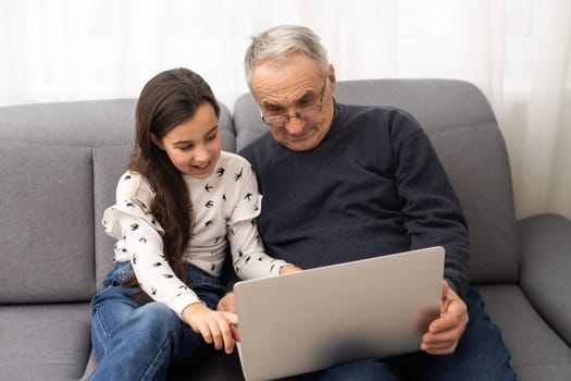 grandfather and granddaughter with laptop.