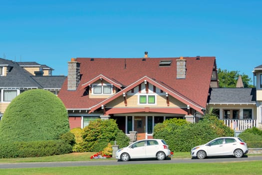 Luxury residential house with two small cars parked in front.