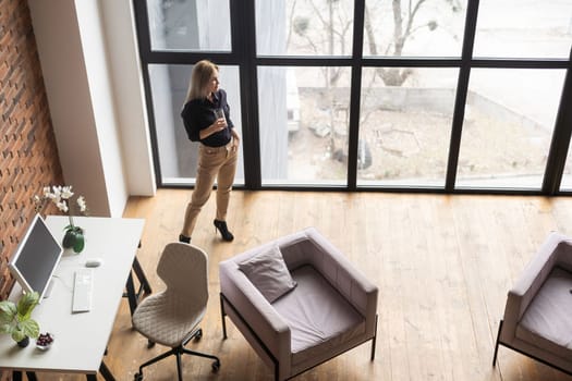 pretty, young and blond woman stylish in a sustainable office.