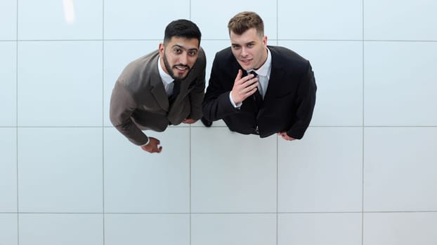 Portrait of two concentrated businessmen partners dressed in formal suit walking and having conversation during working meeting