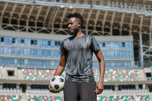 confident black football player holding the ball in his hand