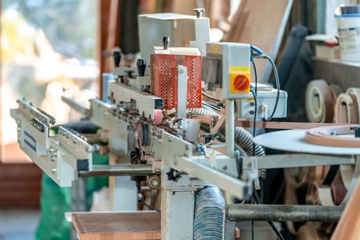 gluing the edge on a machine to a laminate board for the production of furniture in carpentry. High quality photo