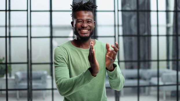 footage of a happy young businessman clapping in a modern office.