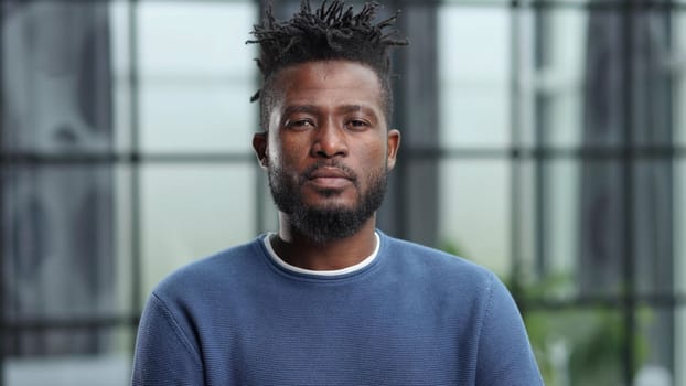Handsome charming cheerful african american businessman in chic colorful casual clothes, in an office building