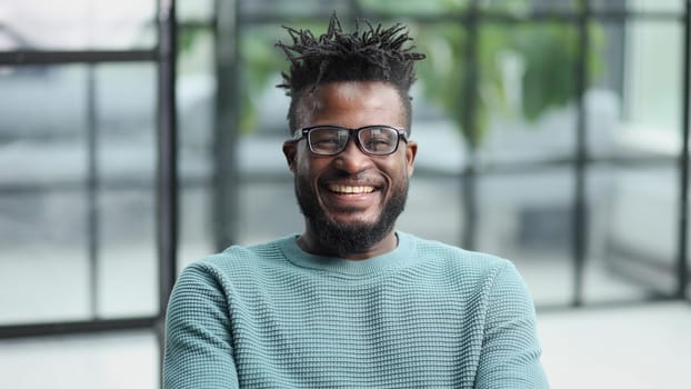 African American man in green sweater looking at camera