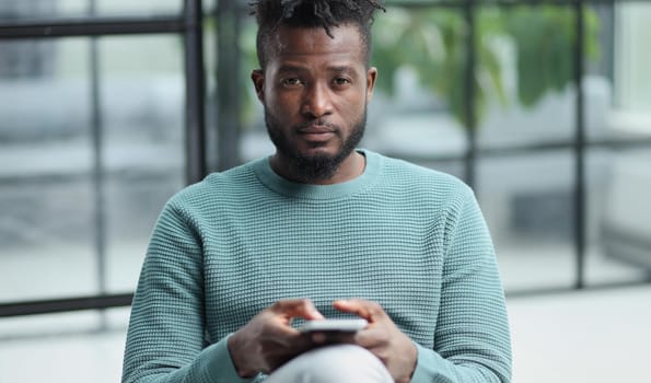 african american businessman using phone mobile corporate apps at workplace texting sms.