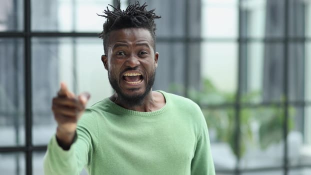 Handsome businessman pointing his finger to the camera and slicking virtual image or text. Young african american guy