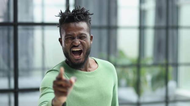 Handsome businessman pointing his finger to the camera and slicking virtual image or text. Young african american guy