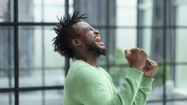 African man rejoices at the victory with his hands up