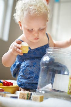 The building blocks of development. A sweet little baby girl playing with wooden blocks