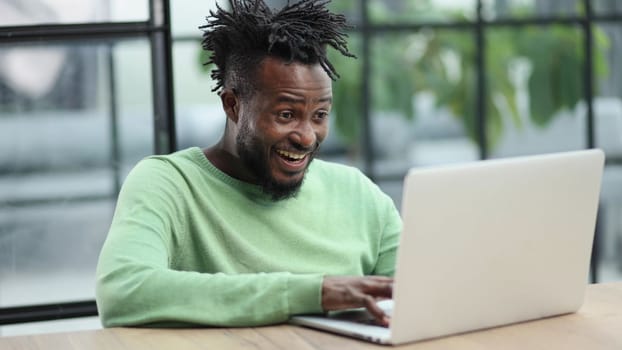 Close-up of a laughing african american man looking into a laptop