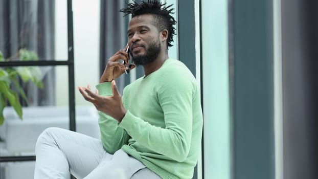 Smiling young adult african american hipster business man professional making business call talking on the phone