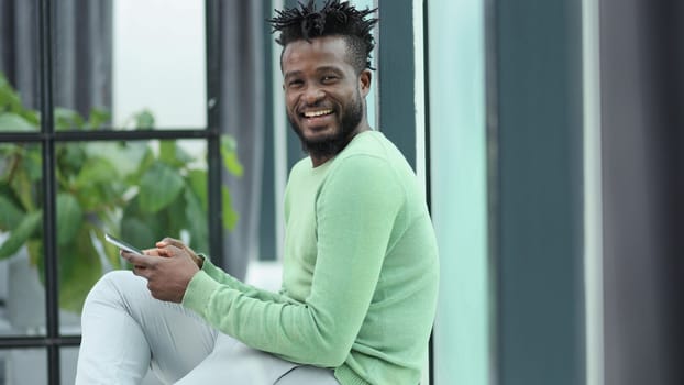 Smiling young adult african american hipster business man professional making business call talking on the phone