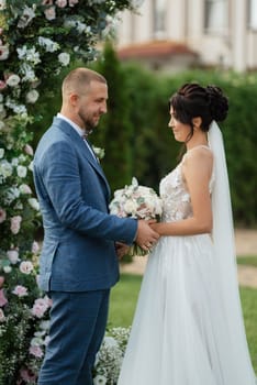 wedding ceremony of the newlyweds on the glade near the restaurant