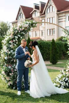 wedding ceremony of the newlyweds on the glade near the restaurant