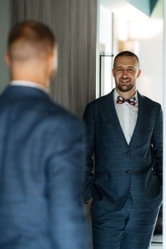 portrait of smiling groom with beard in blue color suit