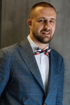 portrait of smiling groom with beard in blue color suit