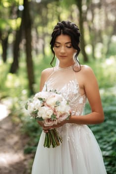 portrait of an elegant bride girl on a path in a deciduous forest