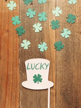 Flat lay with hat and clover on wooden table with lucky lettering. High quality photo
