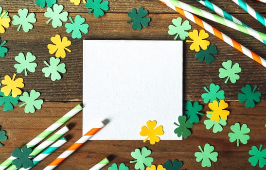 holiday composition for St. Patrick's Day. Festival mockup on a wooden background with straws for drinks and four-leaf clover for good luck
