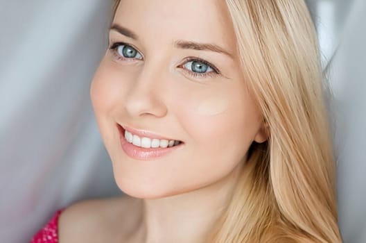 Beautiful blonde woman with liquid make-up foundation on her skin.