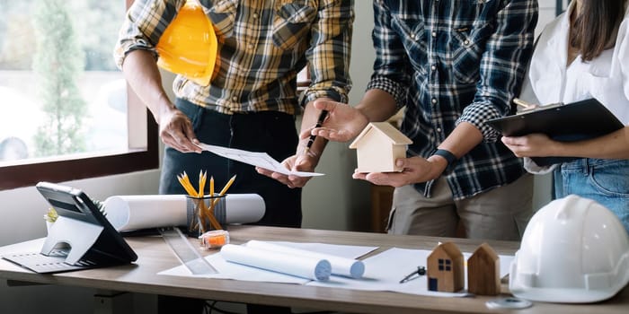 architect and engineer inspect housing estate building to success construction plan before send quality housing to customers. smart team discuss and review construction plan.