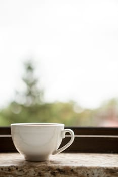 Coffee mug on a window sill. Morning coffee