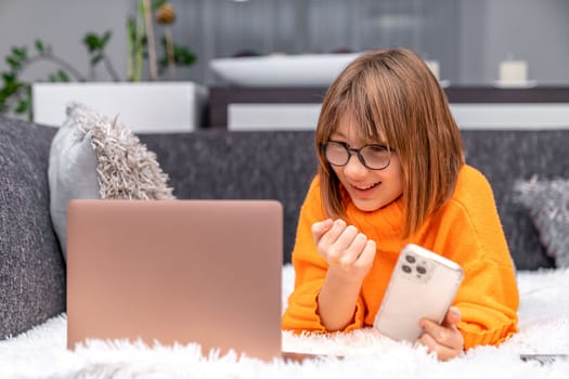 child rejoices success in front of laptop screen. High quality photo