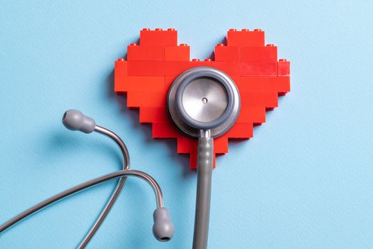 stethoscope standing on red heart on blue background