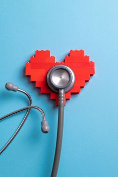 stethoscope standing on red heart on blue background