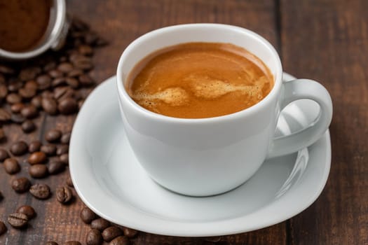 Fresh double espresso coffee and coffee beans on wooden table