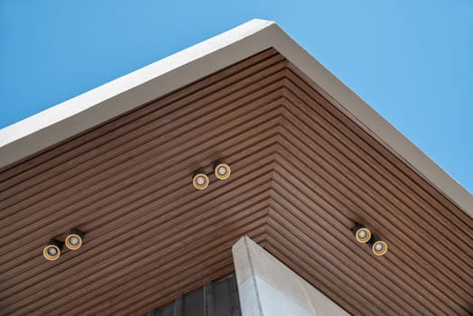 PVC ceiling panel covered with wood-like vinyl with modern lighting installed on it