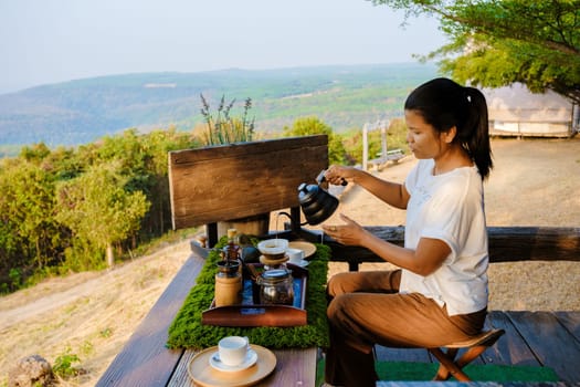 women making drip coffee in the mountains of Thailand. Asian woman preparing coffee on a tented camp