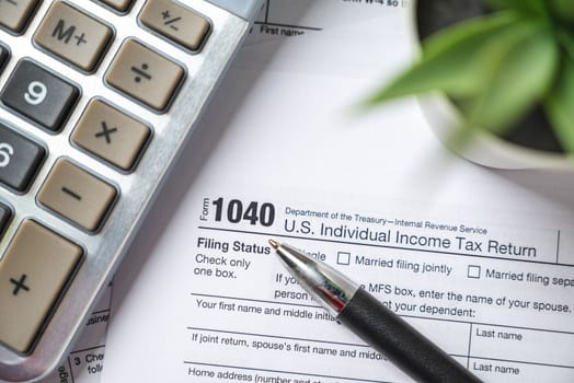 Financial time tax return forms with pen and calculator