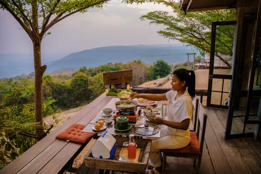 Thai Barbecue Buffet in the mountains on a tented camp, Thai style Grilled Sliced pork Thai Barbeque. Women having dinner in the mountains