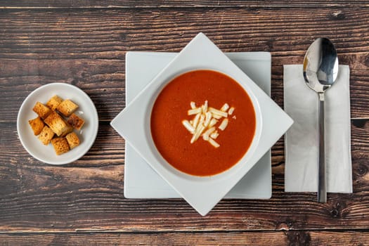 Tomato soup with cheese in white porcelain bowl