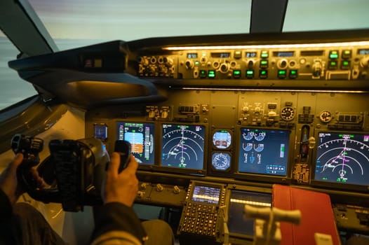 A man is studying to be a pilot in a flight simulator. Close-up of male hands navigating an aircraft