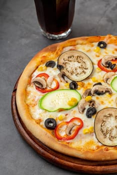 Vegetarian pizza with eggplant, zucchini and mushrooms on dark stone table